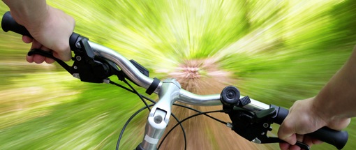Mountainbike. Blick über den Fahrradlenker bei schneller Abfaht im freien Gelände.